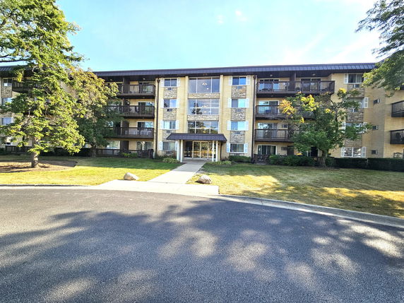Front view of a multi-story apartment building with multiple balconies.