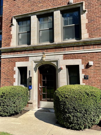 Front view of a building with brick exterior and large windows.
