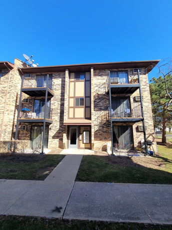 Front view of a multi-story apartment building with balconies.