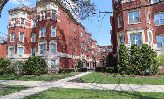 Front view of a multi-story brick apartment building with decorative architectural details.