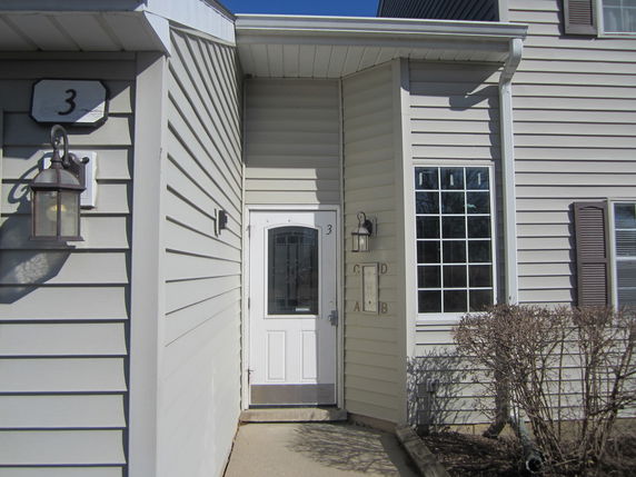 Front view of a house with a white door and large window.