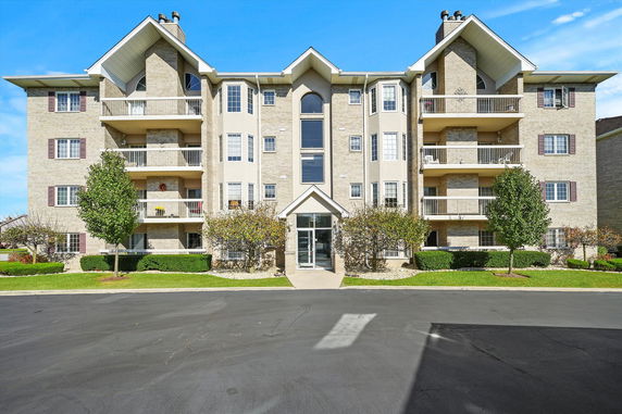 Front view of a multi-story apartment building with balconies.