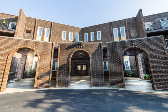Front view of a multi-story brick building with archways.
