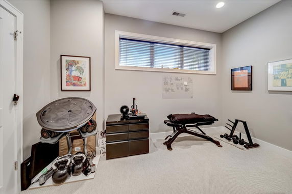 Home gym area with exercise equipment and workout bench.