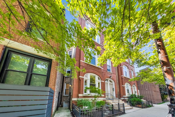 Front view of a multi-story brick building with arched windows.