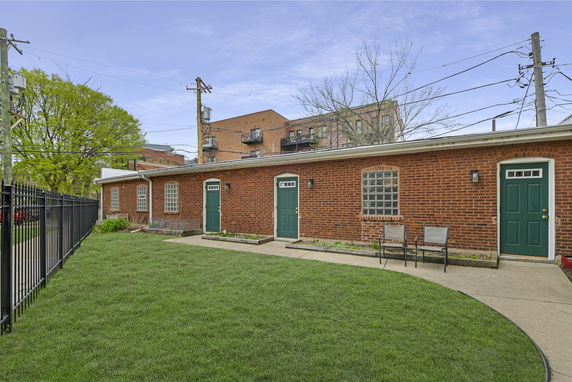 Front view of a single-story brick building with green doors.