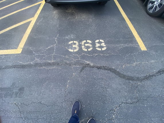 Numbered outdoor parking space with a car parked.