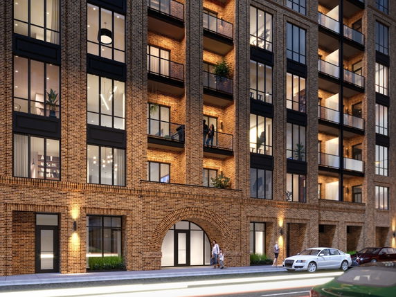 Front view of a multi-story apartment building with balconies and large windows.