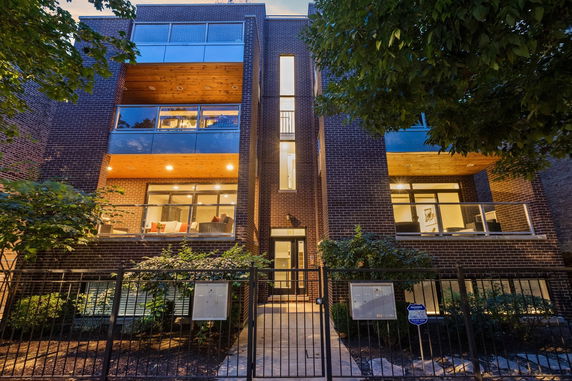 Front view of a modern multi-story building with large windows and balconies.