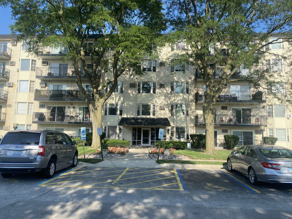 Front view of a multi-story apartment building with balconies.