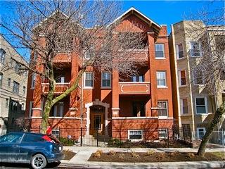 Front view of a multi-story brick building with balconies.