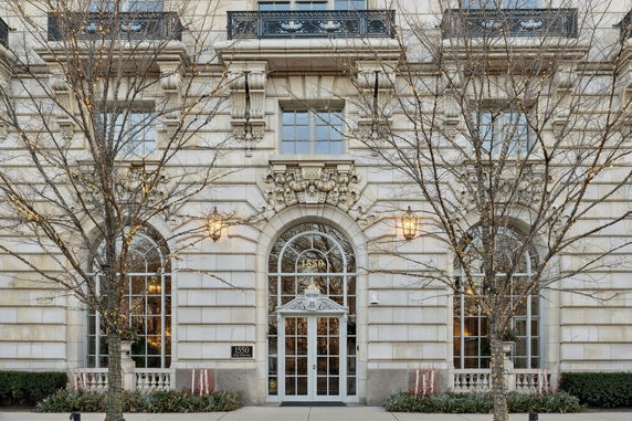 Front view of a multi-story building with ornate architecture and large arched windows.