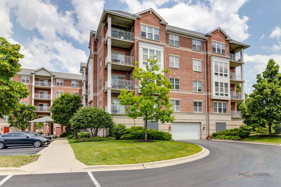 Front view of a multi-story brick apartment building with balconies.