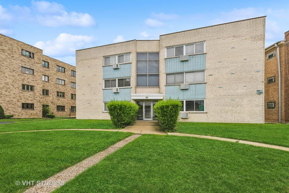 Front view of a mid-century modern apartment building with a central entrance.