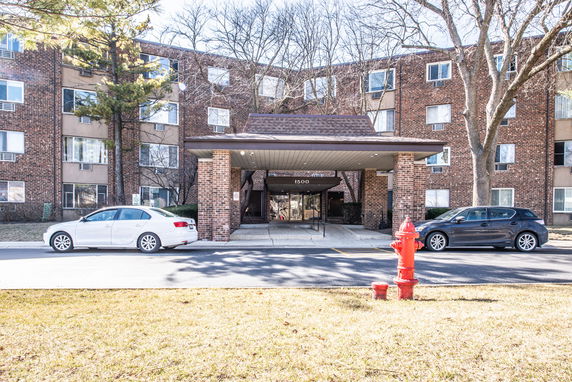Front view of a multi-story brick building with a covered entrance.