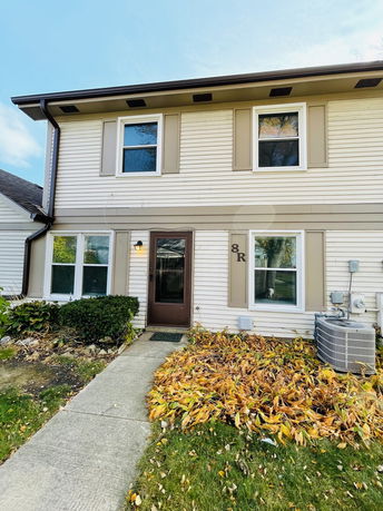 Front view of a two-story house with a pathway leading to the entrance.