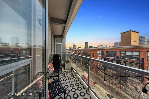View from a balcony overlooking urban buildings with a clear sky.