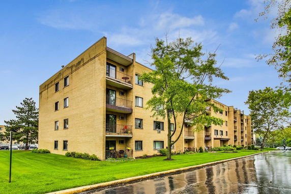 Front view of a four-story residential apartment building with balconies.