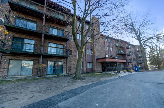 Front view of a multi-story apartment building with balconies.