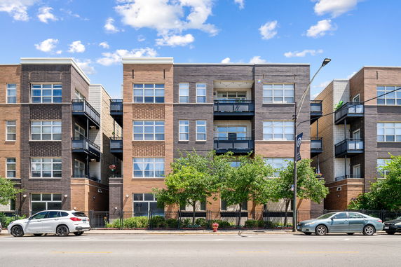 Front view of a modern multi-story apartment building with balconies.