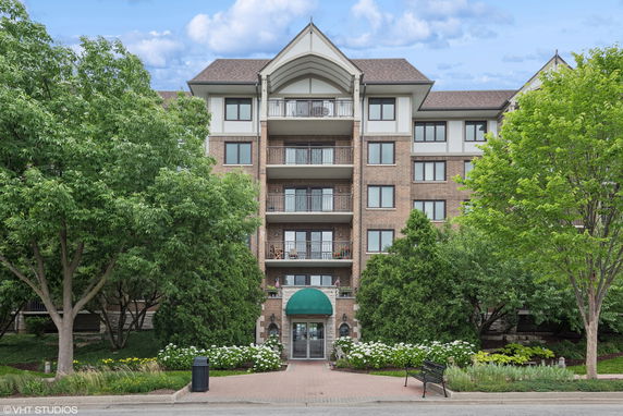 Front view of a multi-story residential building with brick facade and balconies.
