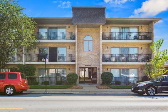 Front view of a three-story apartment building with balconies.