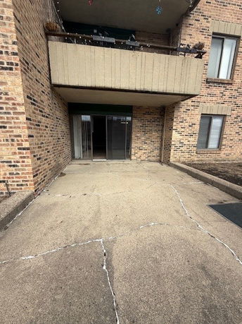 Front view of a building with a brick exterior and a glass sliding door leading to a patio area.