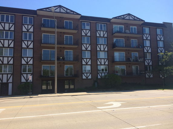 Front view of a multi-story apartment building with balconies.