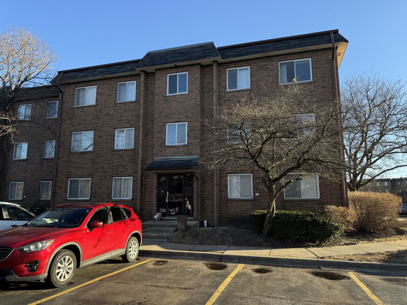 Front view of a three-story brick apartment building.