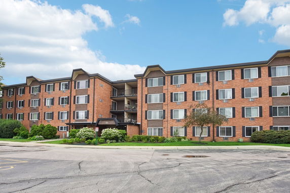 Front view of a four-story brick apartment building.