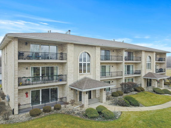 Front view of a multi-story apartment building with balconies.