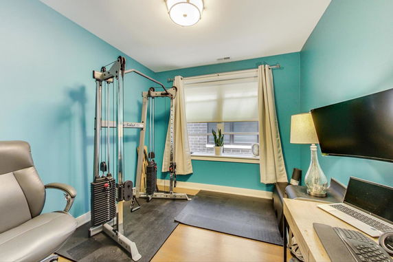 Indoor room with exercise machine and desk setup.