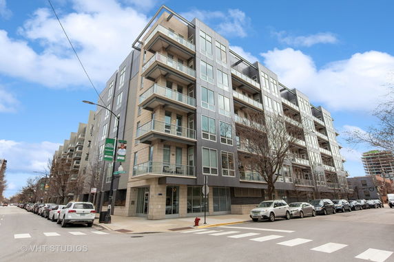 Front view of a modern multi-story apartment building with balconies.