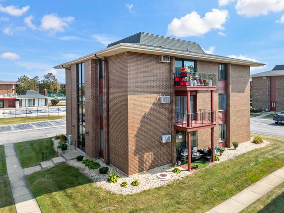 Front view of a three-story apartment building with balconies.