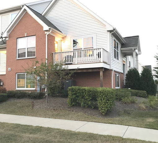 Front view of a multi-story house with brick and siding exterior.