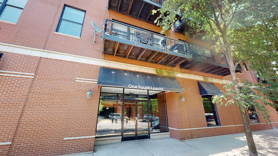 Front view of a multi-story brick building with balconies.