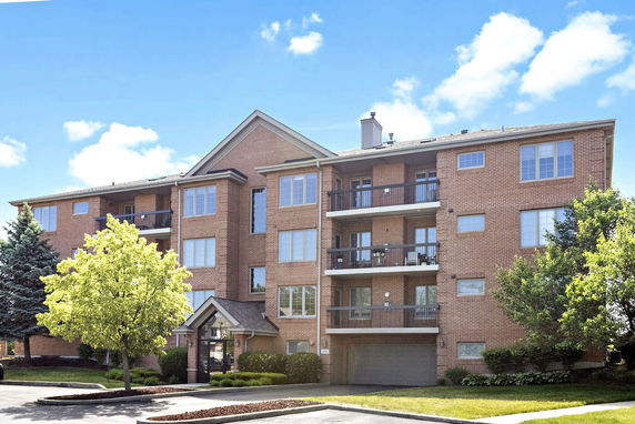 Front view of a multi-story brick apartment building with balconies.