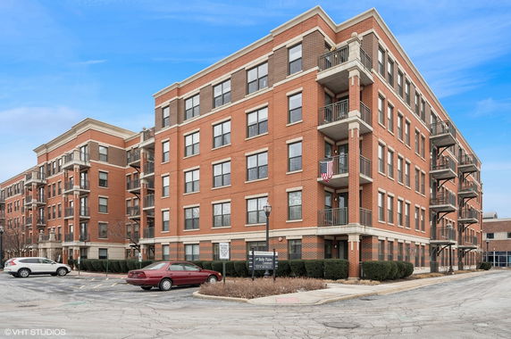 Front view of a multi-story brick apartment building with balconies.