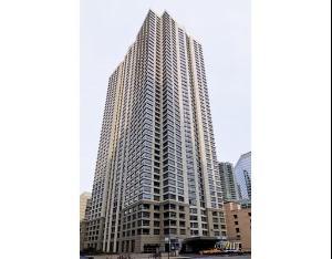 Front view of a tall residential building with multiple balconies.