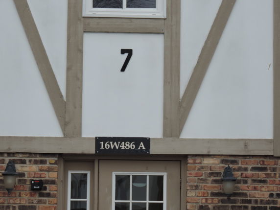 Front view of a house with a brick exterior and numbered address plaque.