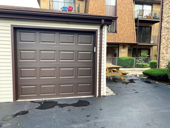 Garage with a brown door and driveway.