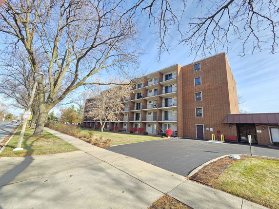 Front view of a multi-story brick building with balconies.