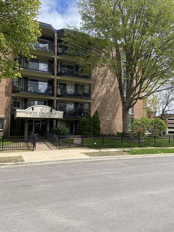 Front view of a condominium building with multiple balconies and a central entrance.