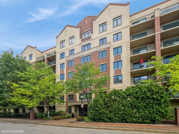 Front view of a multi-story residential building with brick and beige exterior.