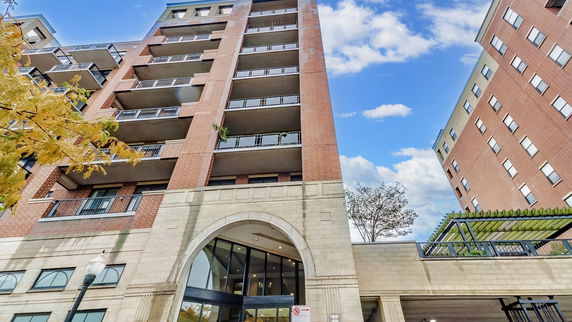Front view of a multi-story brick building with balconies.