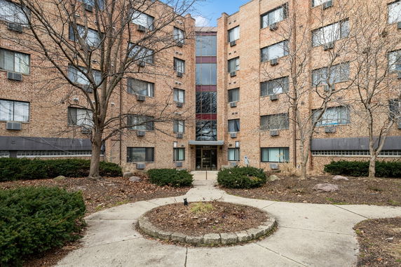 Front view of a multi-story apartment building with brick facade.