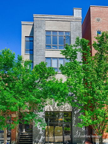 Front view of a multi-story modern building with large windows.