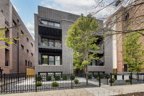 Front view of a modern multi-story brick building with balconies.