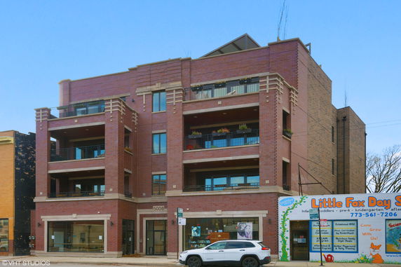 Front view of a four-story brick building with balconies.