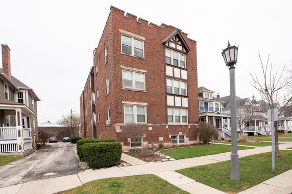 Front view of a multi-story brick building with a decorative facade.